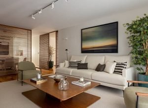 Apartamento em tons terrosos claros tem painéis ripados como divisórias